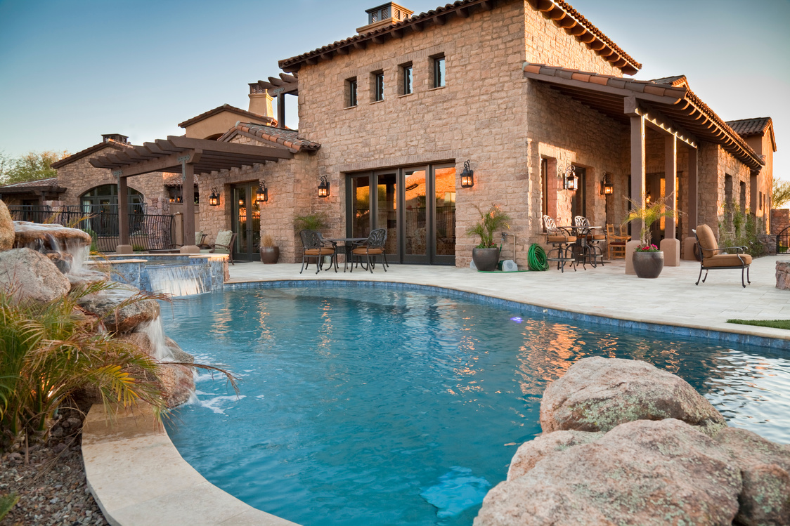 Backyard view of luxury home with swimming pool